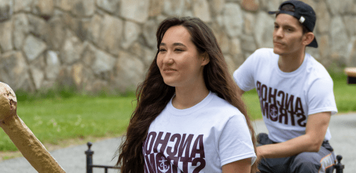 两名学生穿着印有“anchor strong”字样的t恤，在校园里微笑