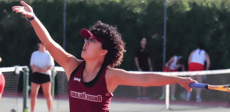 Tennis player outstretches her arms to hit ball